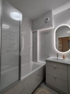een witte badkamer met een bad en een wastafel bij ApartamentySnu, Bulwary II z parkingiem in Radom