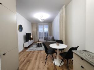 a kitchen and living room with a table and chairs at ApartamentySnu, Bulwary II z parkingiem in Radom