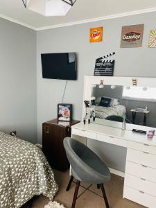 a bedroom with a desk and a bed and a mirror at Hermosa Casa en buen barrio residencial in Castro