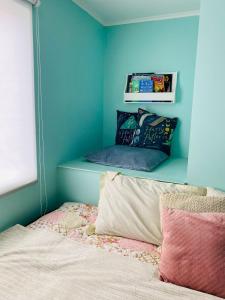 a bedroom with a bed with a blue wall at Hermosa Casa en buen barrio residencial in Castro