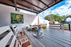 a table with two glasses of wine on a deck at Villa Picasso private Pool in Playa Blanca