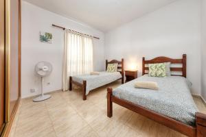 a bedroom with two beds and a fan at Villa Picasso private Pool in Playa Blanca
