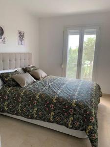 西曼卡斯的住宿－Casa adosada con jardín en Entrepinos by InsideHome，一间卧室配有一张带花卉棉被的床