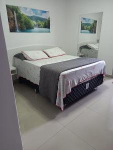 Un dormitorio con una cama con una manta. en Hotel Farrapos, en Porto Alegre