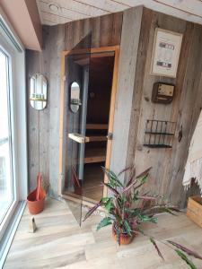 Habitación con pared de madera y puerta de cristal. en Chambre D'eau, en Ichtegem