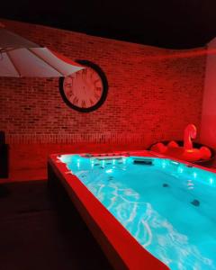 una gran piscina con un reloj en una pared de ladrillo en Chambre D'eau, en Ichtegem