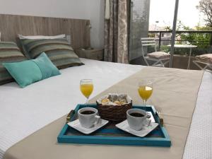 a tray with two drinks and a basket of food on a bed at AIRES VERDES PREMIUM in Salta