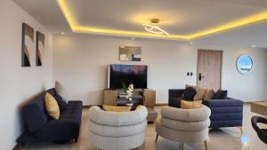 a living room with couches and chairs and a tv at 302 Departamento La Terraza in Cuenca