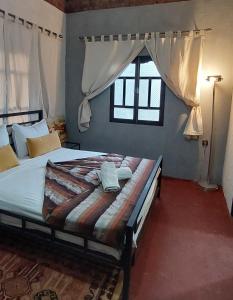 a bedroom with a large bed with a window at Riad dar idsalah in Ouirgane
