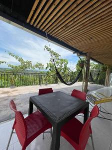a black table and chairs on a patio with a hammock at Cabaña Campestre con Piscina en la Hacienda Nápoles in Doradal +10 photos