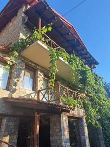 Kamienny dom z bluszczem na boku w obiekcie Lydia Lithos Mountain Resort w mieście Metamorfosi
