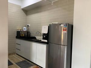 a kitchen with a refrigerator and a sink at Menara Arina Uniti in Kuala Lumpur