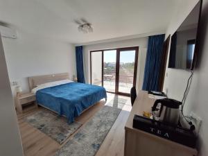 een slaapkamer met een bed met blauwe lakens en een raam bij TREND in Arad