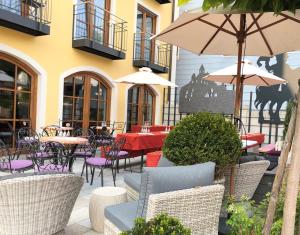 an outdoor patio with tables and chairs and umbrellas at Hotel Wurzer in Tännesberg