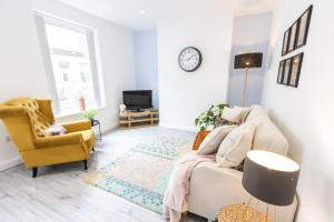 a living room with a couch and a tv at Cambridge Mews - Central Hebden Bridge in Hebden Bridge