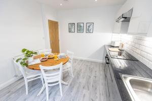 a kitchen with a table and chairs in a kitchen at Cambridge Mews - Central Hebden Bridge in Hebden Bridge