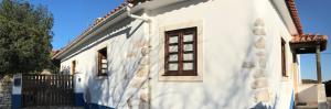een wit huis met een raam aan de zijkant bij Lili's - Alojamento Local in Monsanto
