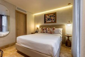 um quarto com uma grande cama branca e uma janela em Voilá Centro Histórico em Cartagena de Indias