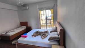 Habitación pequeña con 2 camas y ventana en Appartamento familiare di Toni, en Shkodër