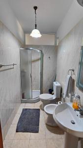 baño con 2 aseos y ducha acristalada en Appartamento familiare di Toni, en Shkodër
