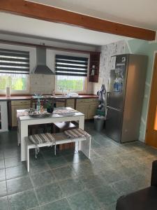 eine Küche mit einem Kühlschrank und einem Tisch darin in der Unterkunft Ferienhaus in der Stienitzaue in Werneuchen