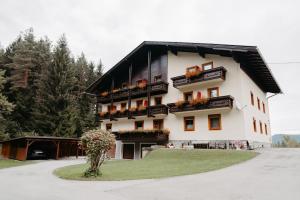 un grand bâtiment blanc avec un toit noir dans l'établissement Pension Waldruh - Tannenheim, à Faak am See