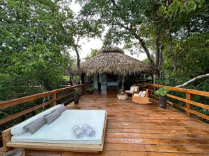um deque de madeira com uma cama e uma cabana em Juma Amazon Lodge em Autazes