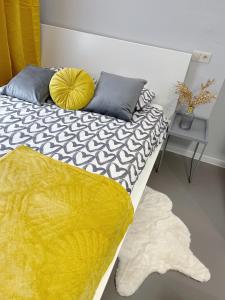 カトヴィツェにあるKościuszki Cozy Apartments Centrumのベッドルーム1室(黄色い毛布とラグ付きのベッド1台付)