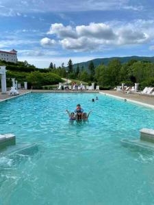 a person swimming in a pool of blue water at Bretton Woods Townhome, Views, 1Gig WiFi, Spacious in Bretton Woods