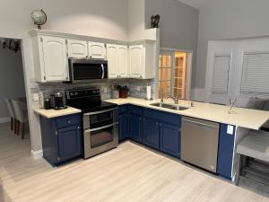 a kitchen with blue cabinets and a sink at Florida house, 4br 2bt with private pool oasis in Naples