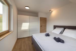 una camera da letto con un letto bianco con due paia di scarpe sopra di Styria Estate, near Terme Olimia Spa Resort a Podplat