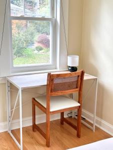 a desk with a chair and a window at 7 Mins drive to Yale, Large fenced yard in New Haven