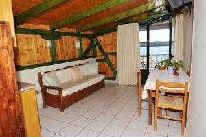 a bedroom with a bed and a table and a window at Logan's Beach Hotel in Nydri