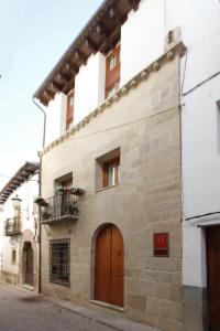 um edifício de pedra com uma porta de madeira e uma varanda em Casa 1340 em Mora de Rubielos