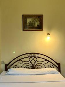 a bed in a bedroom with a picture on the wall at Philo Hotel in Cairo