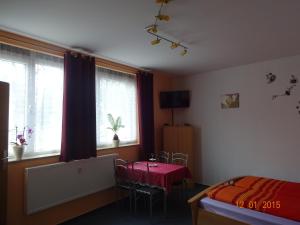 a bedroom with a bed and a table and windows at Ferienwohnung Freund in Weimar