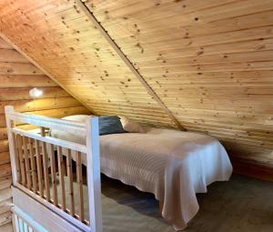 Cama en habitación con techo de madera en Kesäpesä, en Artjärvi