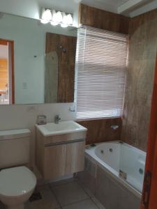 uma casa de banho com um WC, um lavatório e uma banheira em La Cumbre Sierra de los Padres em Sierra de los Padres