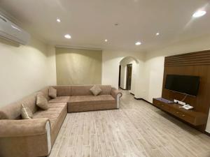 ein Wohnzimmer mit einem Sofa und einem Flachbild-TV in der Unterkunft فيوبارك للشقق الفندقية in Al Hofuf