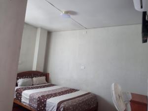 a small bedroom with two beds and a fan at MARANATHA in El Ñuro