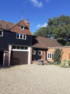 a house with a garage and a picnic table in the driveway at Rural Retreat near Dorking in Dorking