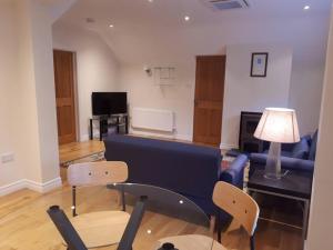 a living room with a blue couch and chairs at Rural Retreat near Dorking in Dorking