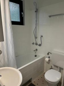 a bathroom with a tub and a toilet and a sink at Cronenberger Apartment mit Garten - kontaktloses Einchecken, Netflix, Kingsize-Bett in Wuppertal