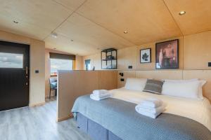 ein Schlafzimmer mit einem großen Bett mit Handtüchern darauf in der Unterkunft Rustic Cabins, sea views from rewilded farm in St Andrews