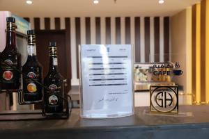 duas garrafas de cerveja sentadas num balcão com um cartaz em جراند أوتيل للشقق المخدومة Grand Otel Serviced Apartments em Jazan