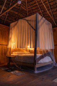 a bed with a canopy in a room at Aparthotel Ayahuaska for SOLO travelers in Iquitos