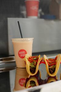 zwei Hot Dogs auf einem Teller neben einem Drink in der Unterkunft Little Mod in Charlottesville