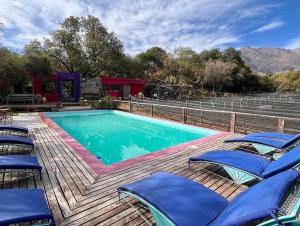 a swimming pool on a wooden deck with chairs at Araoz de Lamadrid Wine Lodge in San Javier