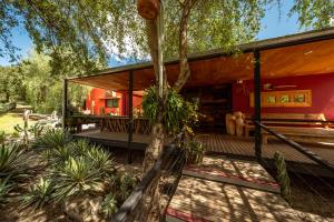 ein Haus mit einer umlaufenden Veranda mit einem Baum in der Unterkunft Araoz de Lamadrid Hotel&Bodega in San Javier