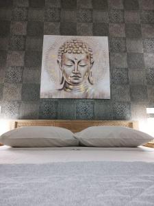 a headboard of a bed with a statue on a wall at Appartamento Villa Matilde in Borgata Zarattini